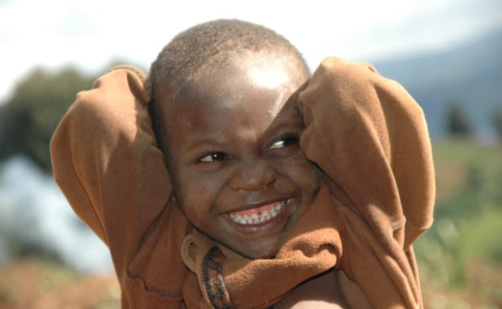 Lachend afrikaans kind met bruine trui