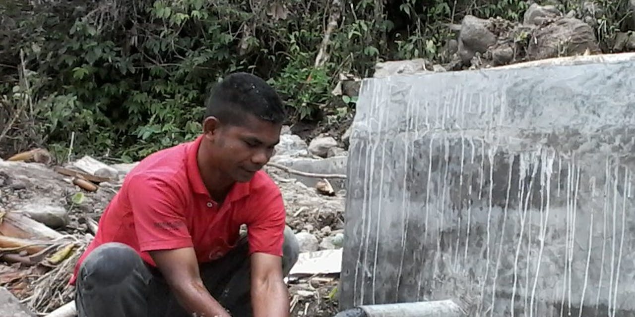 Een jongen wast zijn handen in schoon drinkwater in Indonsië.