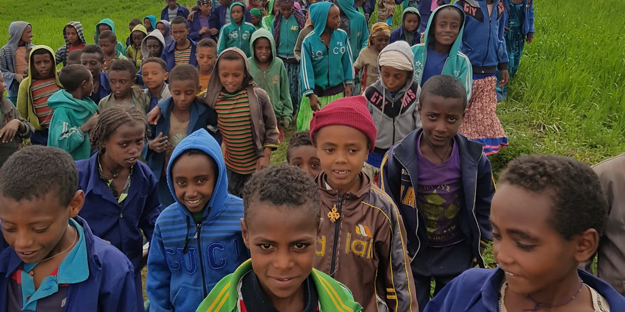 Een grote toeloop van kinderen bij de opening van een waterput in Ethiopië.