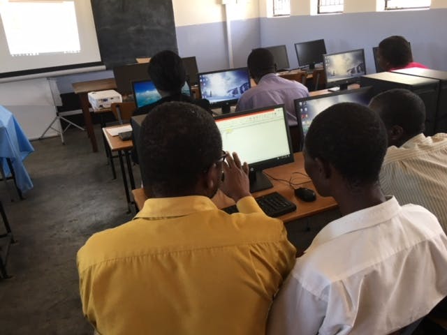 Mensen krijgen computerles op een school in Zimbabwe