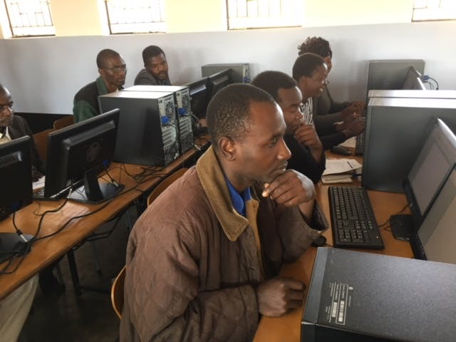 Leraren krijgen computerles op school in Zimbabwe.
