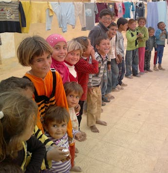 Een rij kinderen in een opvangkamp in Syrie.