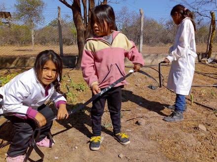 Drie meisjes aan het werk in een moestuin in Argentinië.