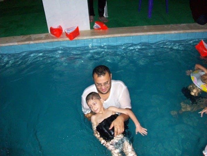 Een vader met zijn zoon in een zwembad voor Fysiotherapie in Libanon.