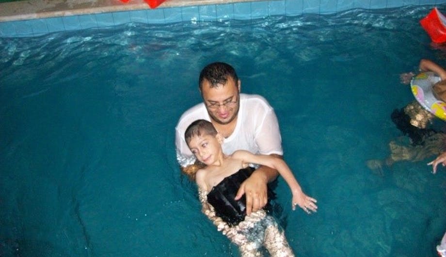 Een vader met zijn zoon in een zwembad voor Fysiotherapie in Libanon.