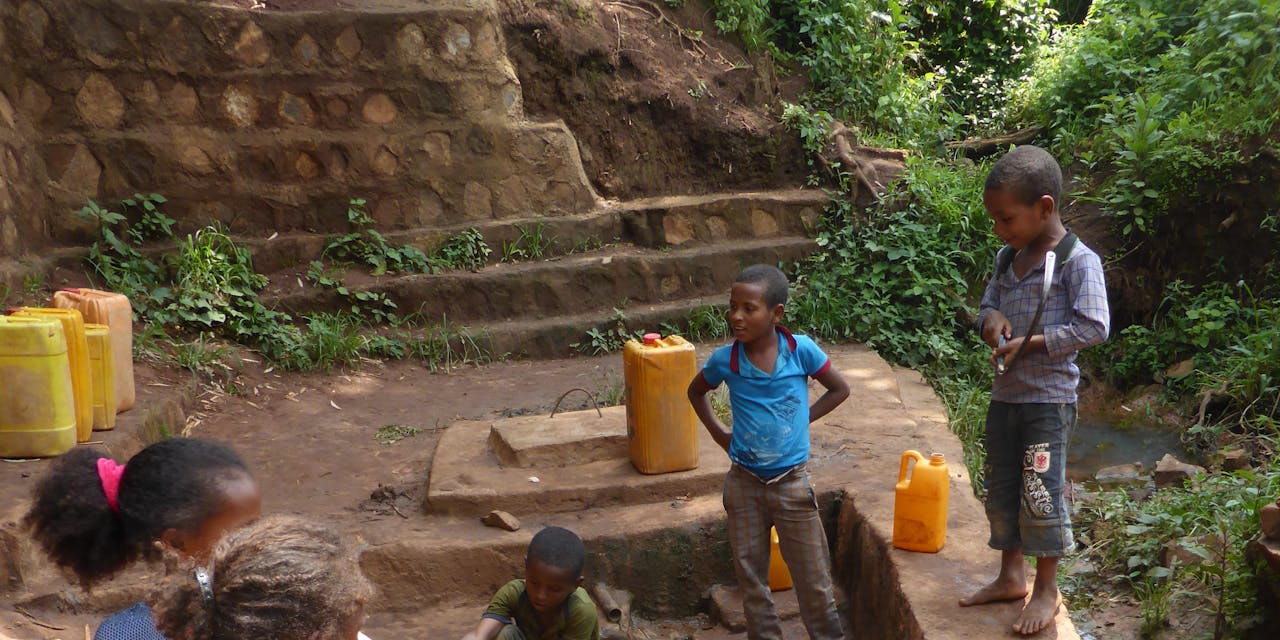Kinderen halen vies water op met een jerrycan.