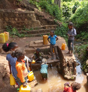 Kinderen halen vies water op met een jerrycan.
