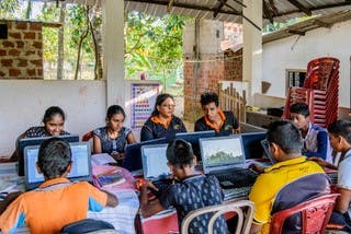 Kinderen aan het werk op hun laptops in Sri Lanka.