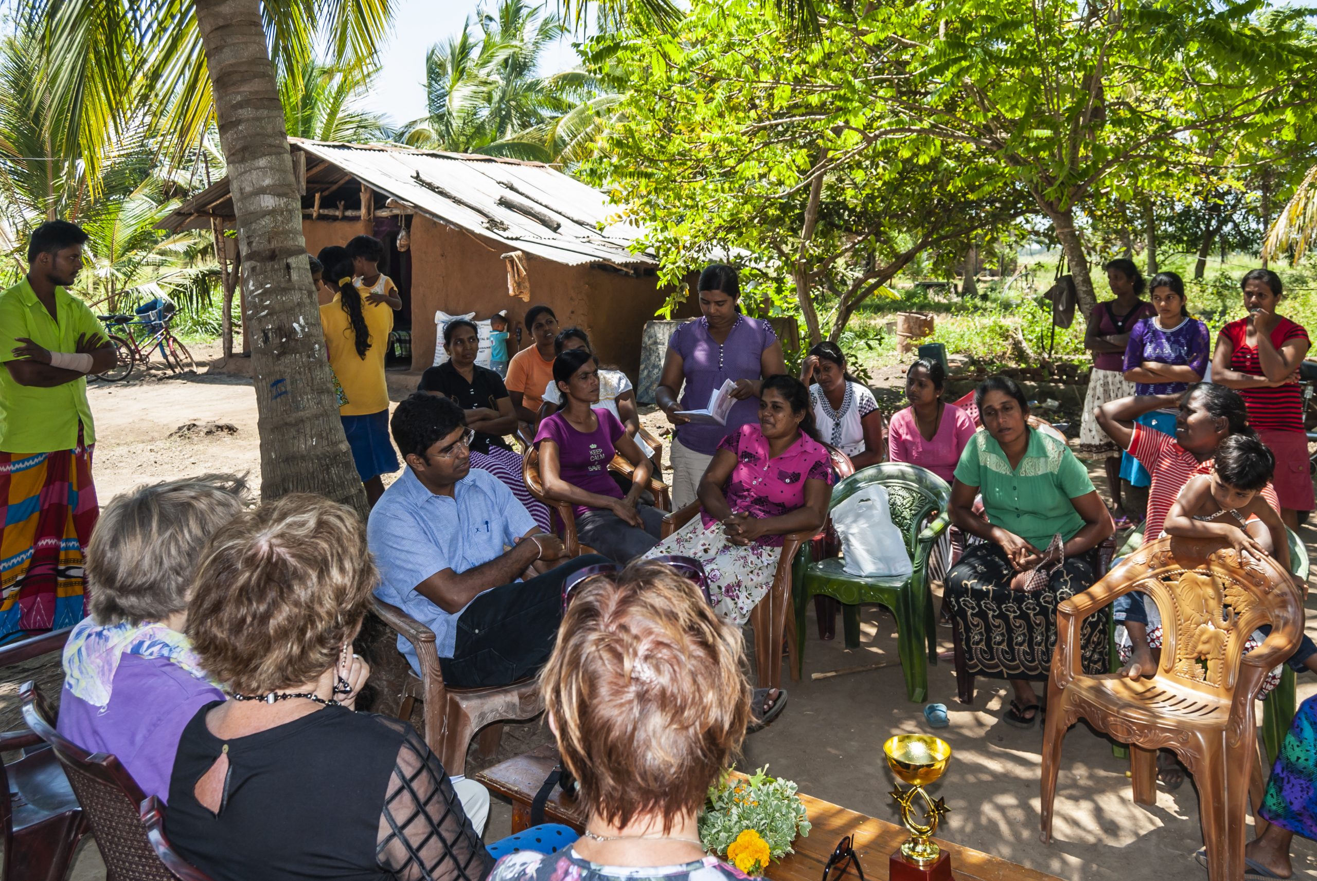 Een vergaderin van een vrouwenvereniging in Sri Lanka, buiten onder een boom.