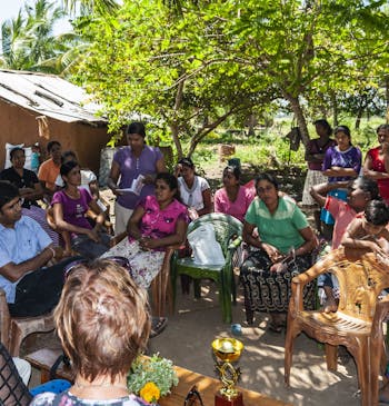 Een vergaderin van een vrouwenvereniging in Sri Lanka, buiten onder een boom.