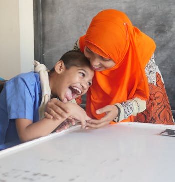 Vrouwen en kind uit Bangladesh lachen samen op school.