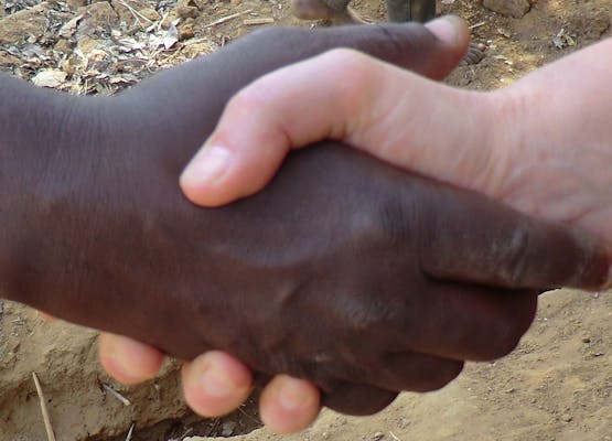 Twee mensen die elkaar een hand geven.