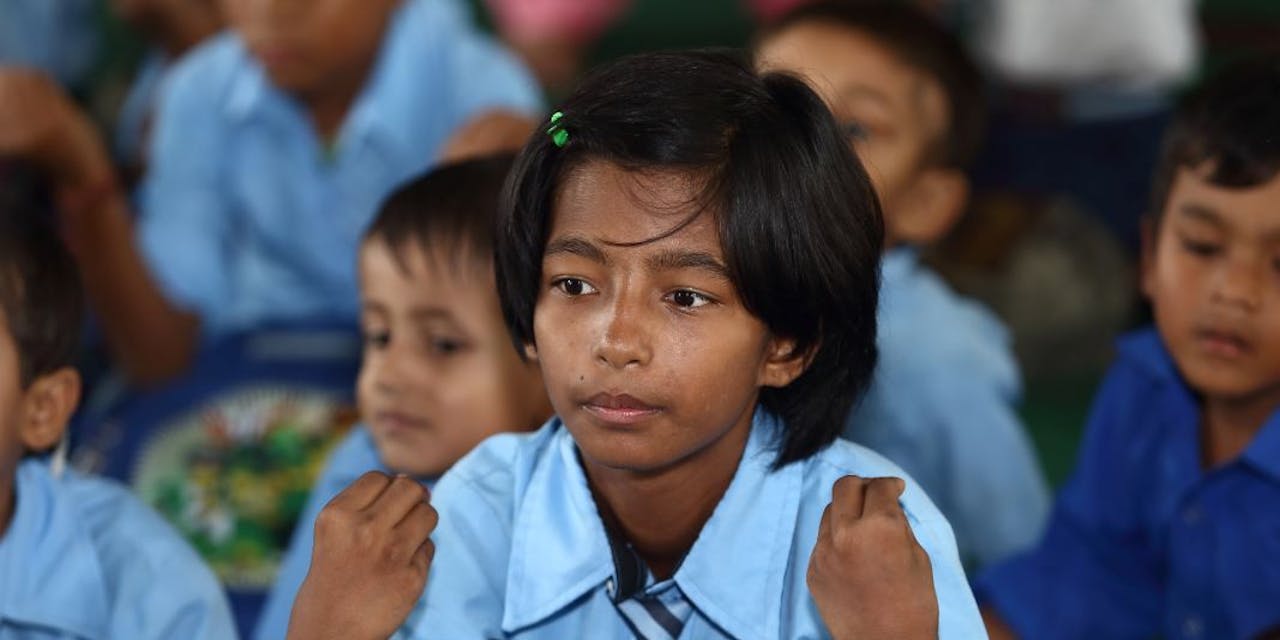 Een meisje oefent handgebaren tijdens een les in Nepal.