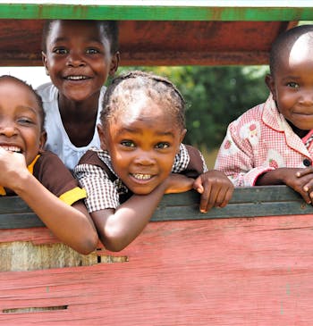 Vier kinderen poseren voor een foto in Zambia.