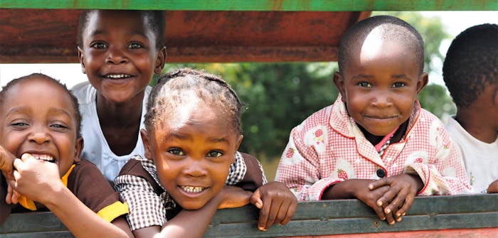 Vier kinderen poseren voor een foto in Zambia.
