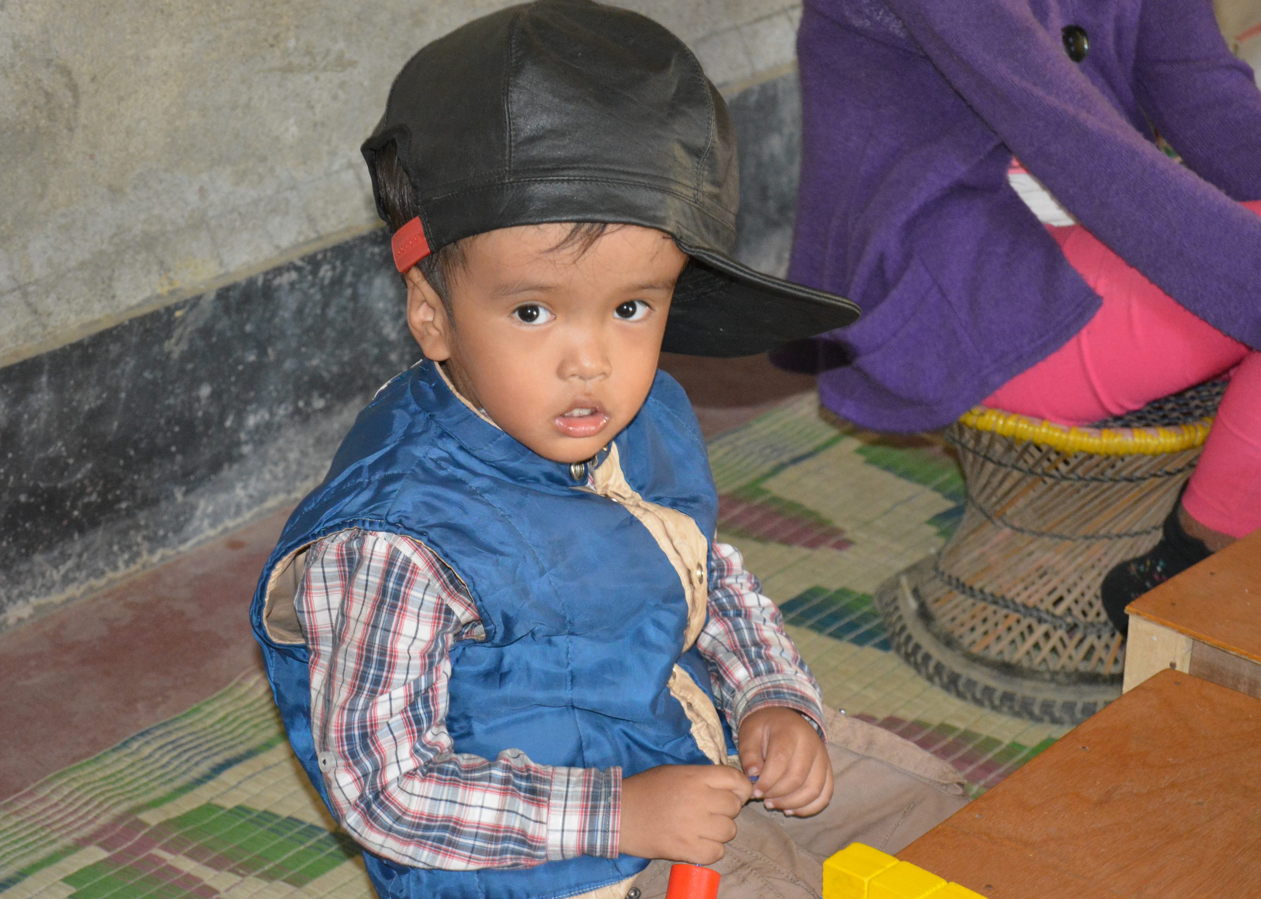 Een jongetje met een beperking kijkt in de camera in India.