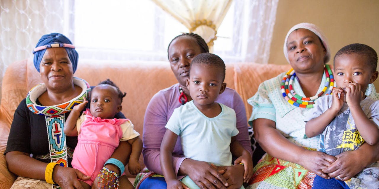 Een Zuid-Afrikaanse familie poseert. Met zonnepanelen kan het centrum waar ze vaak komen verder worden geholpen.