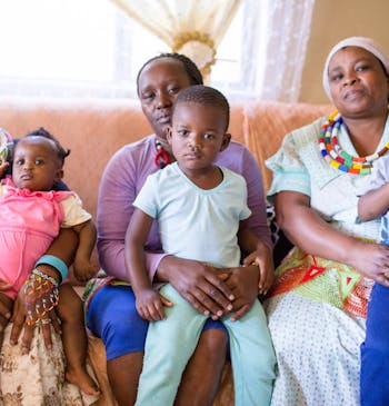 Een Zuid-Afrikaanse familie poseert. Met zonnepanelen kan het centrum waar ze vaak komen verder worden geholpen.