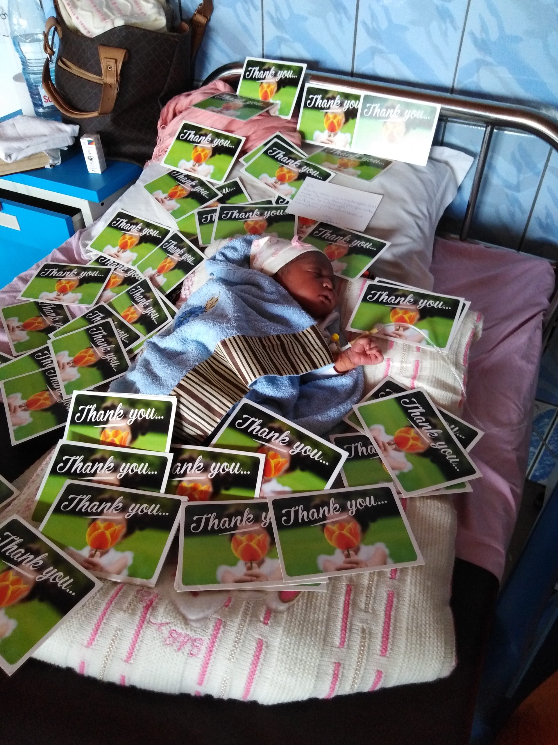 Een baby in Kameroen omringt door kaarten.