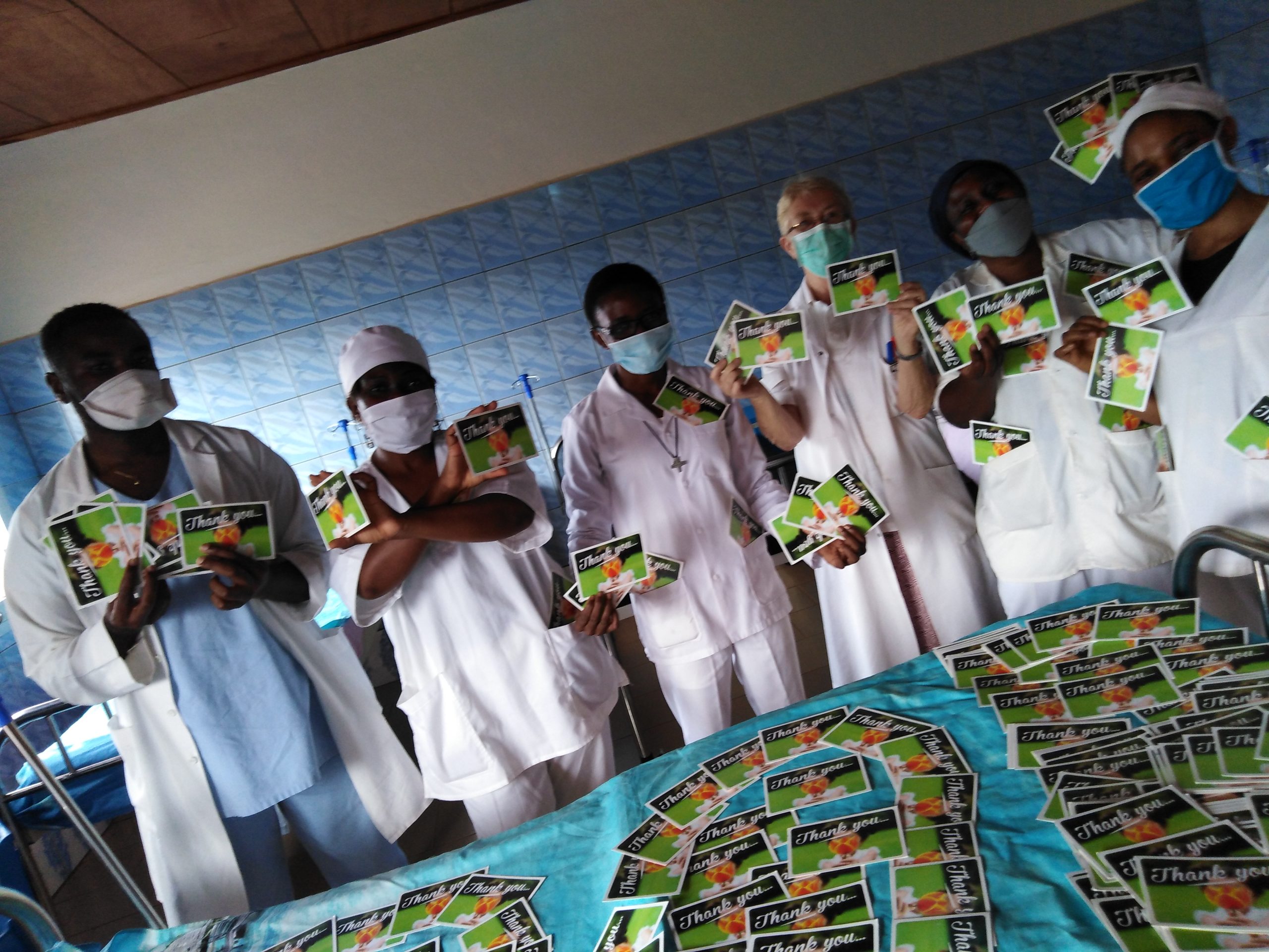 Een groep artsen in Kameroen poseert met kaarten die ze hebben gekregen via de kaartenactie van Wilde Ganzen.