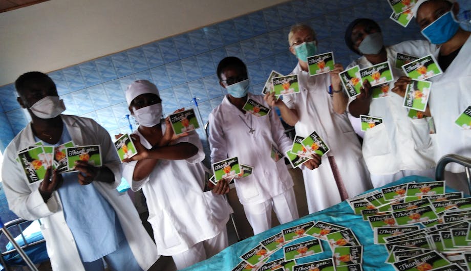 Een groep artsen in Kameroen poseert met kaarten die ze hebben gekregen via de kaartenactie van Wilde Ganzen.