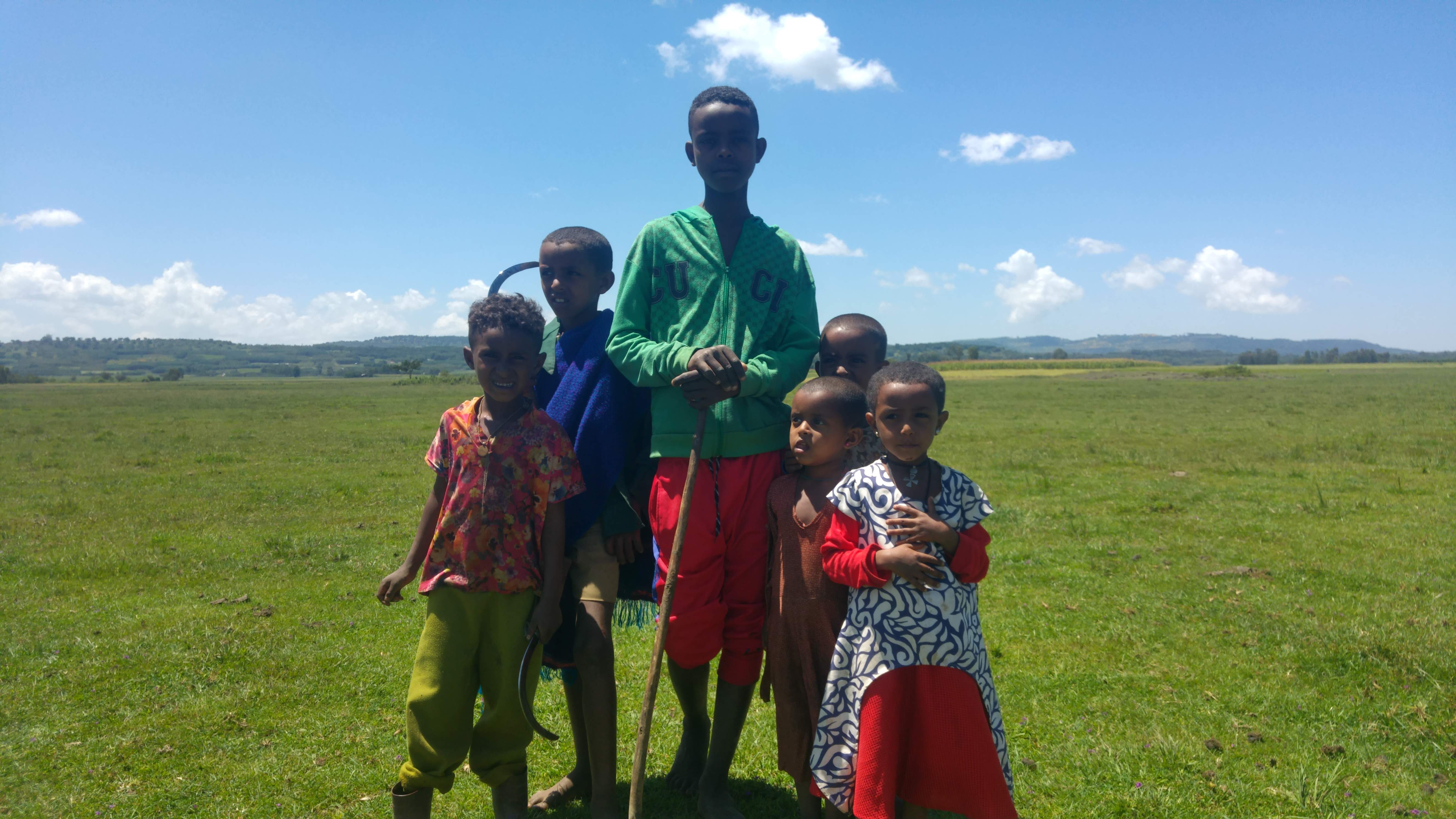 Een groep kinderen poseert op een veld in Ethiopië