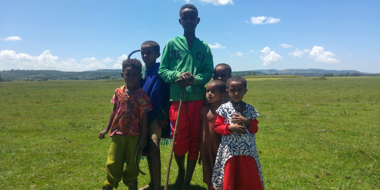 Een groep kinderen poseert op een veld in Ethiopië