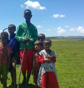 Een groep kinderen poseert op een veld in Ethiopië