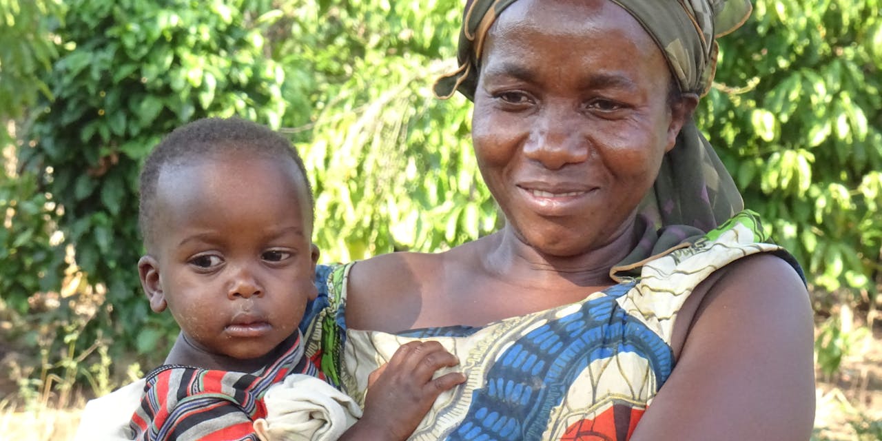 Een moeder met haar kind in de armen in Oeganda.