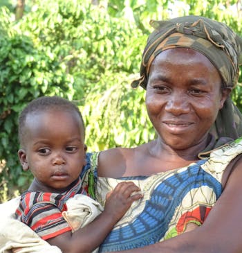 Een moeder met haar kind in de armen in Oeganda.