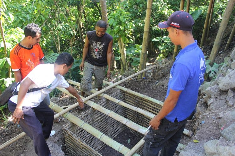 Vier mannen bouwen aan nieuwe toiletten in Indonesië.