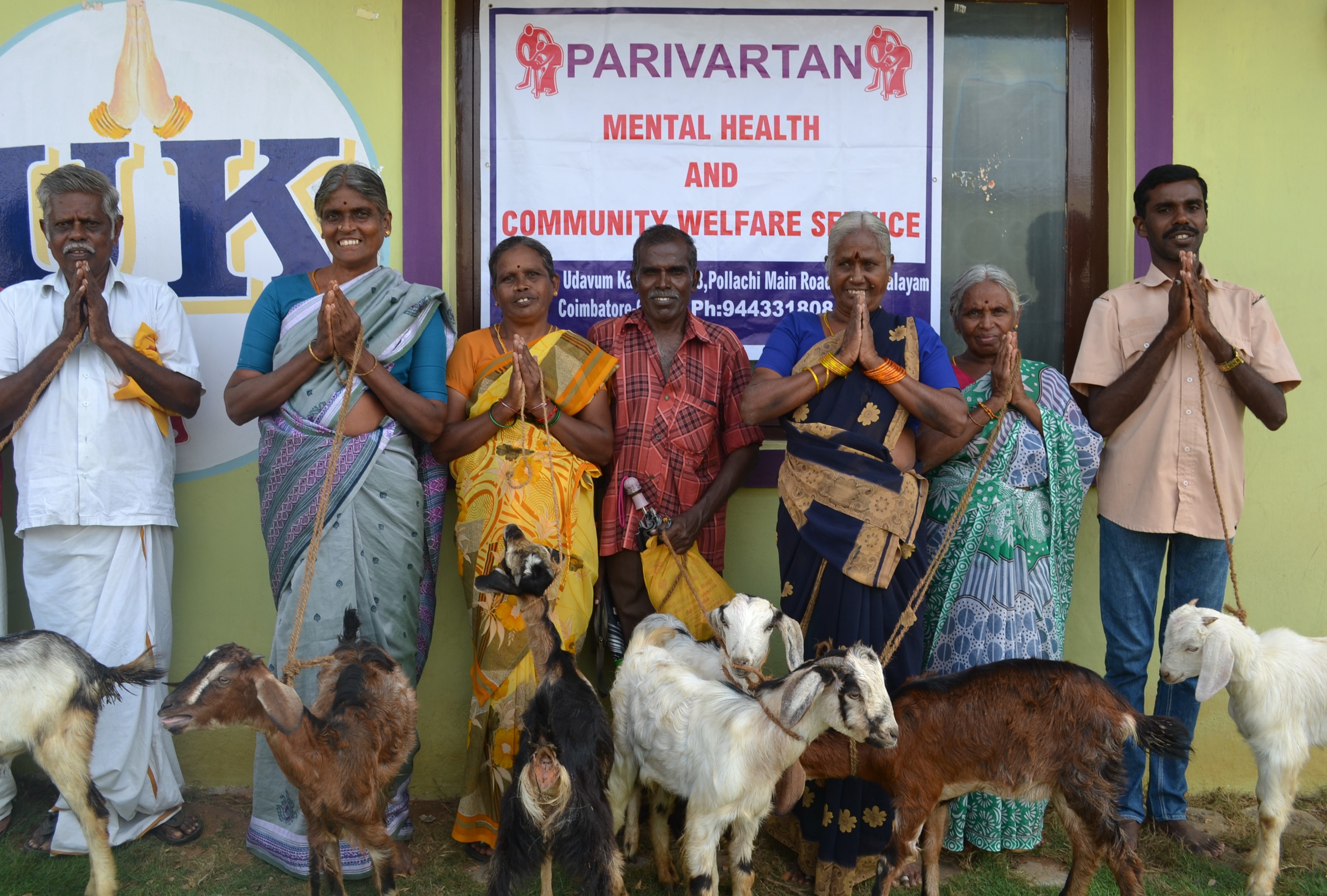 Zeven Indiaase vrouwen poseren met hun geiten in India.