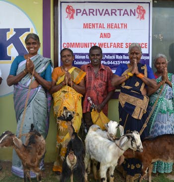 Zeven Indiaase vrouwen poseren met hun geiten in India.