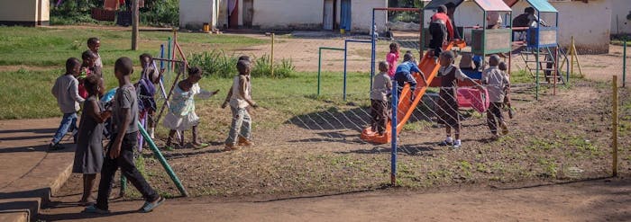 Een groep kinderen speelt in een speeltuintje in Zambia.