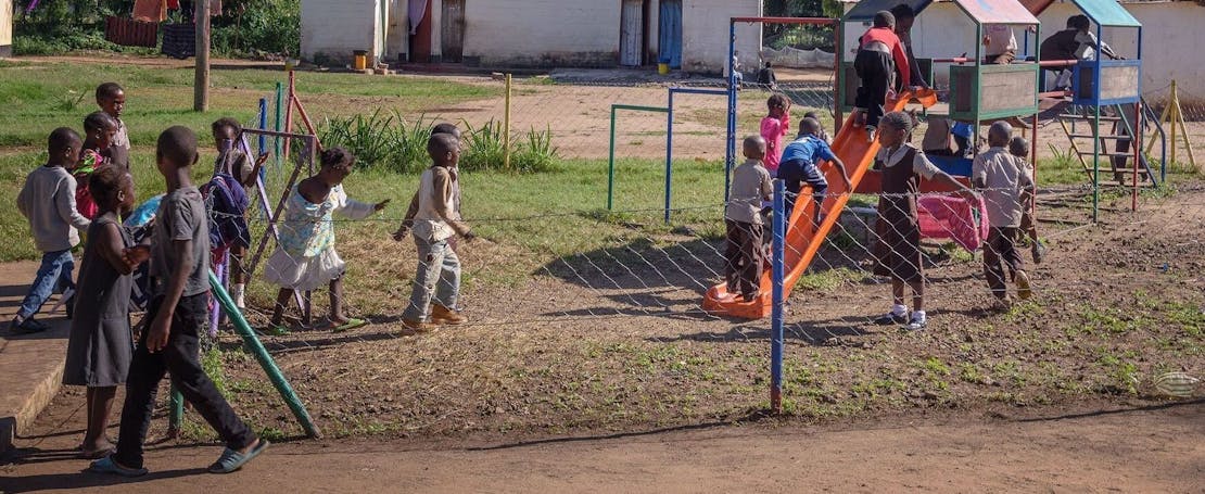 Een groep kinderen speelt in een speeltuintje in Zambia.
