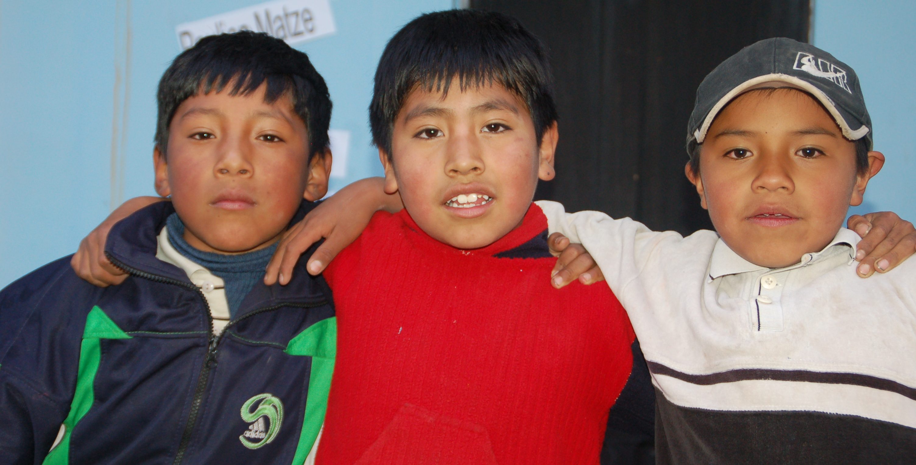 Drie jongetjes uit groep drie in een klas in Bolivia.