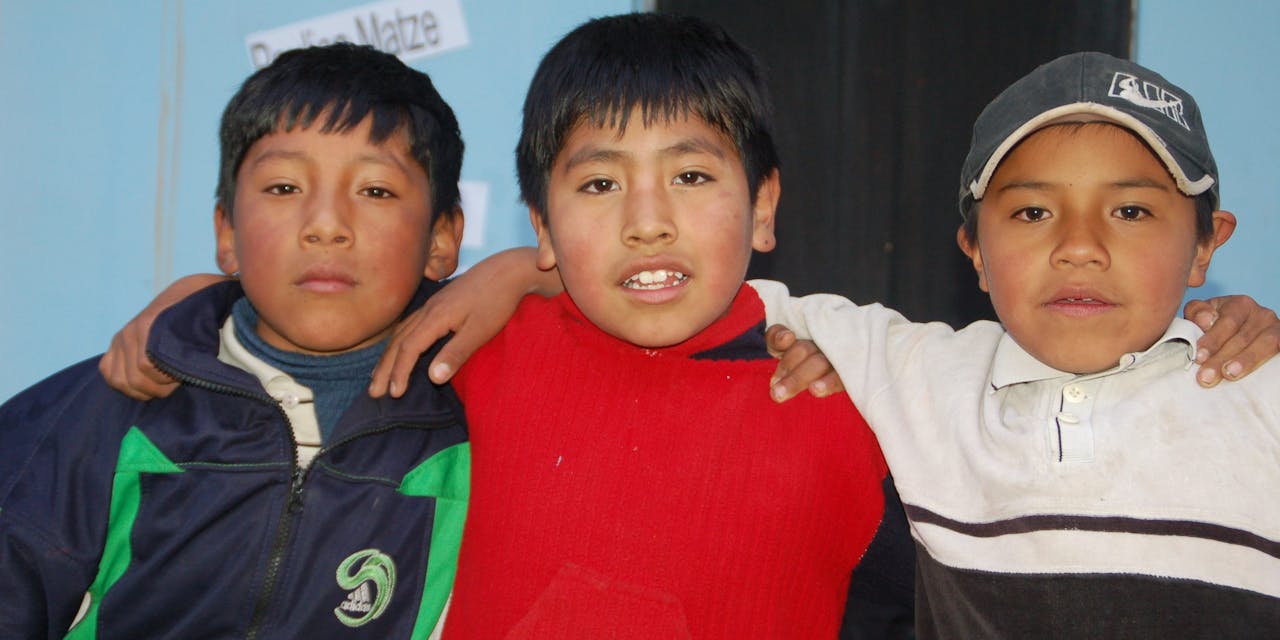 Drie jongetjes uit groep drie in een klas in Bolivia.