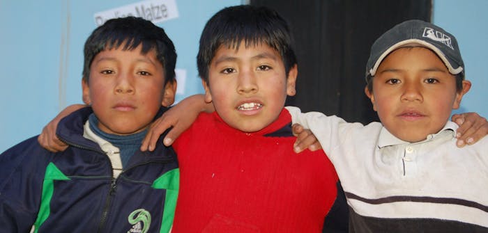 Drie jongetjes uit groep drie in een klas in Bolivia.