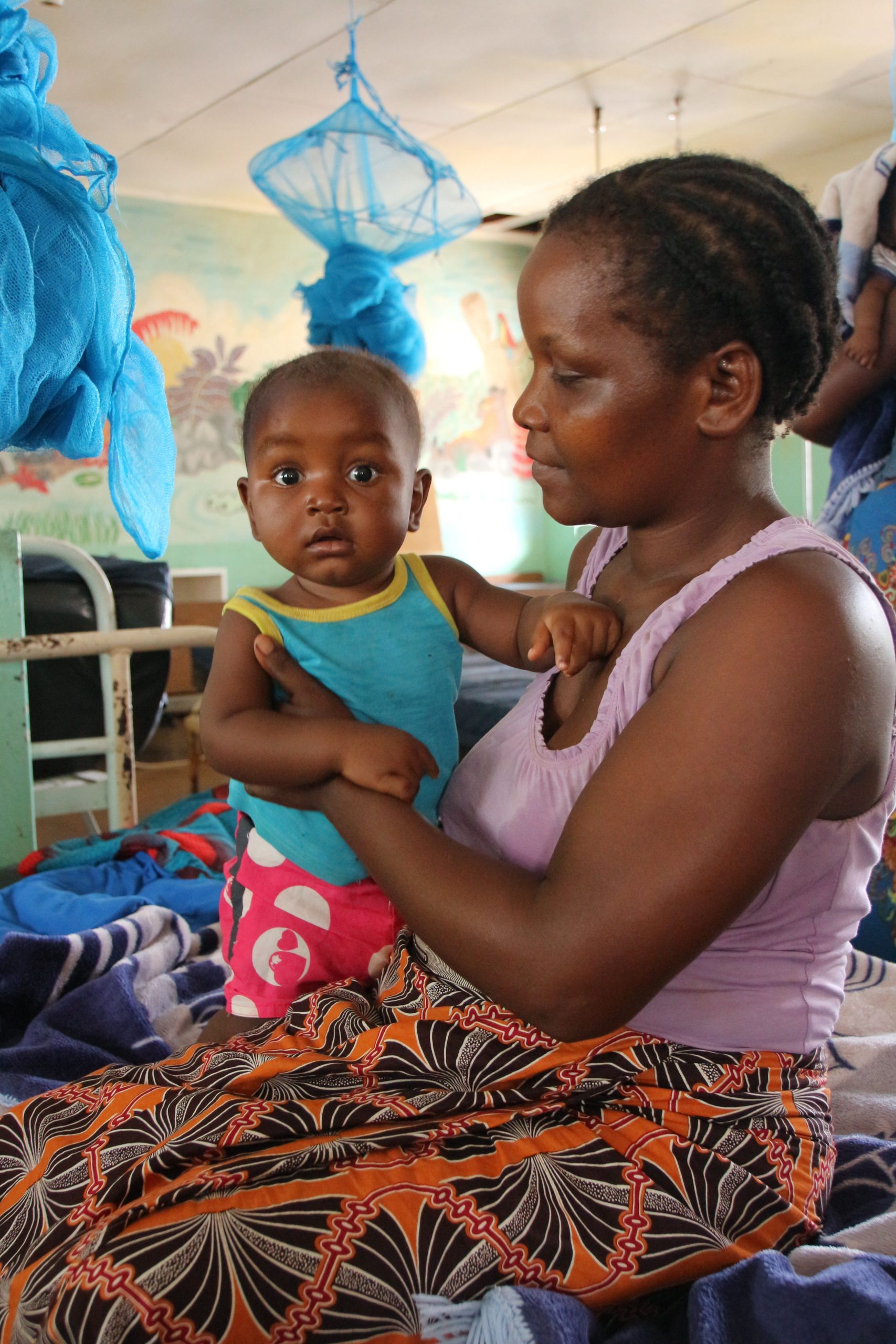 Een vrouw met een kindje in een ziekenhuis in Malawi.