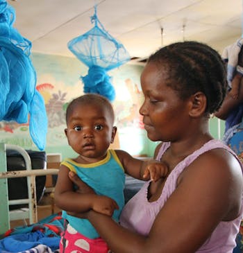 Een vrouw met een kindje in een ziekenhuis in Malawi.