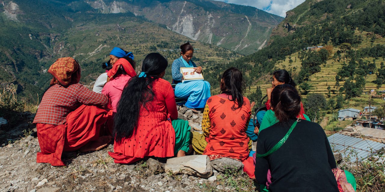 Een vrijwilligster geeft les aan een groep vrouwen in Nepal.