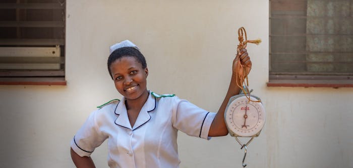 Verpleegster Akuzike Chimwaza laat een draagbare weegschaal zien in Malawi.