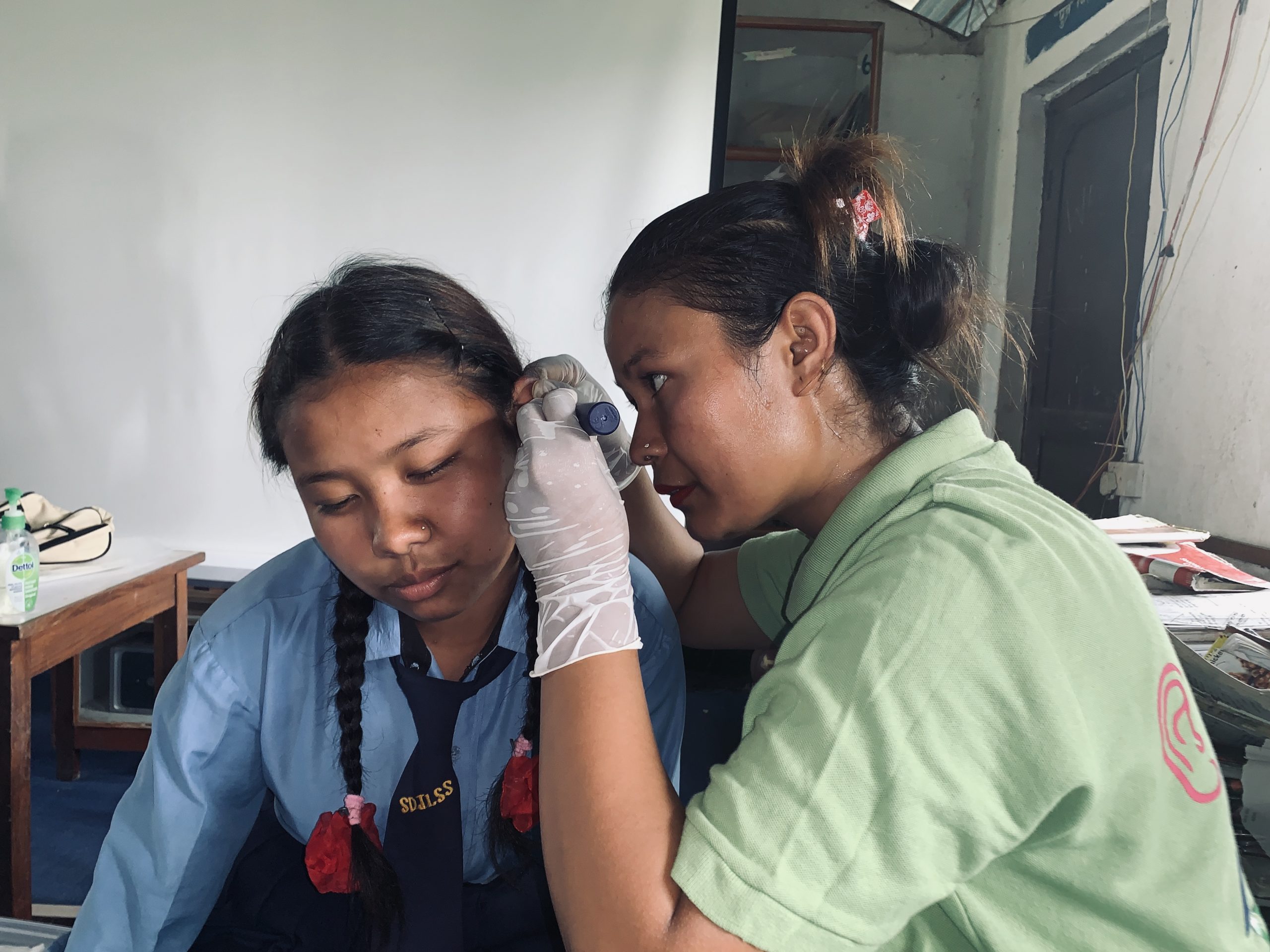 Het linkeroor van een meisje wordt gecontroleerd in Nepal.