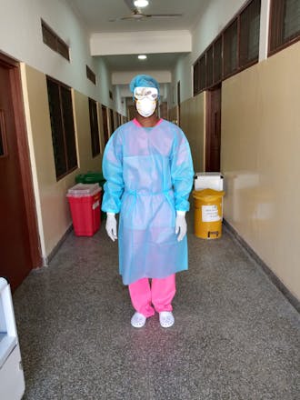 Een vrouw in het ziekenhuis in beschermende kleding.