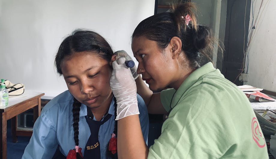 Een meisje krijgt een oorcontrole in Nepal