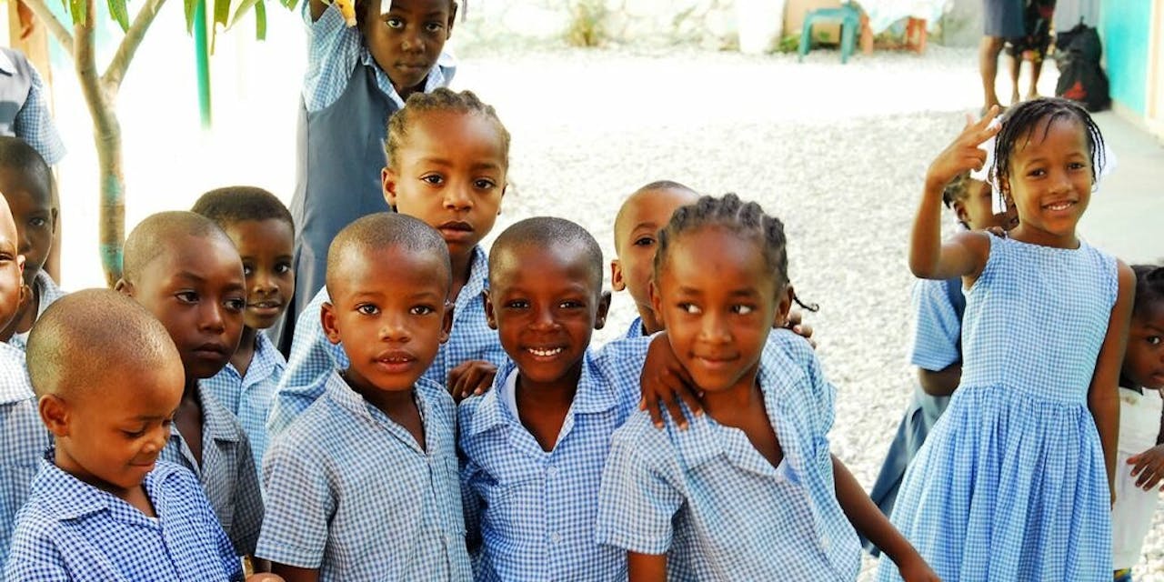 Negen schoolkinderen in uniform in Haïti.