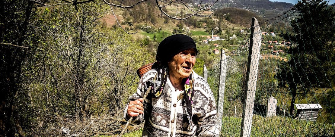 Een oude vrouw met wandelstok in Srebrenica.