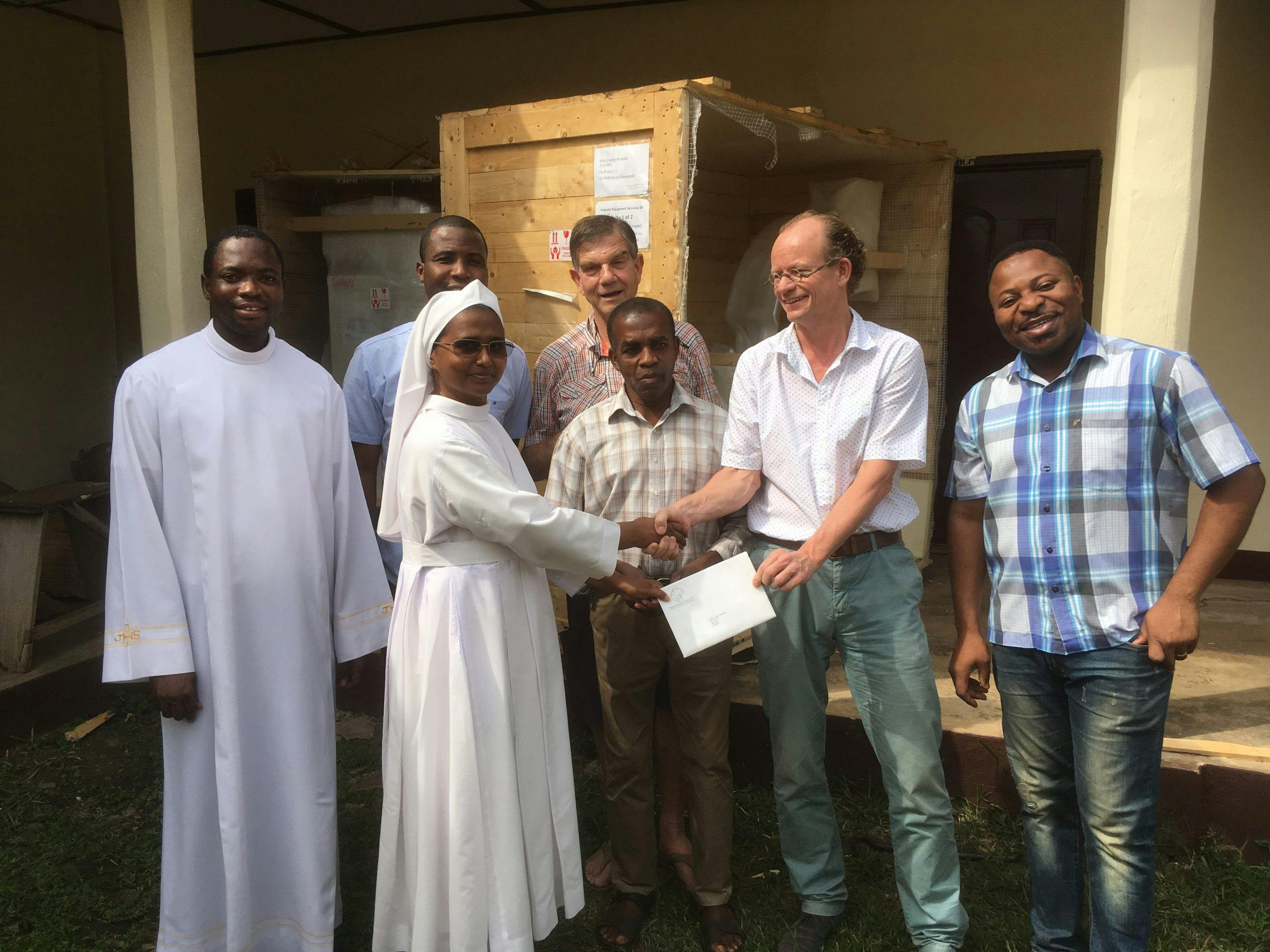 Een groep mensen poseert voor een gebouw na de opening.