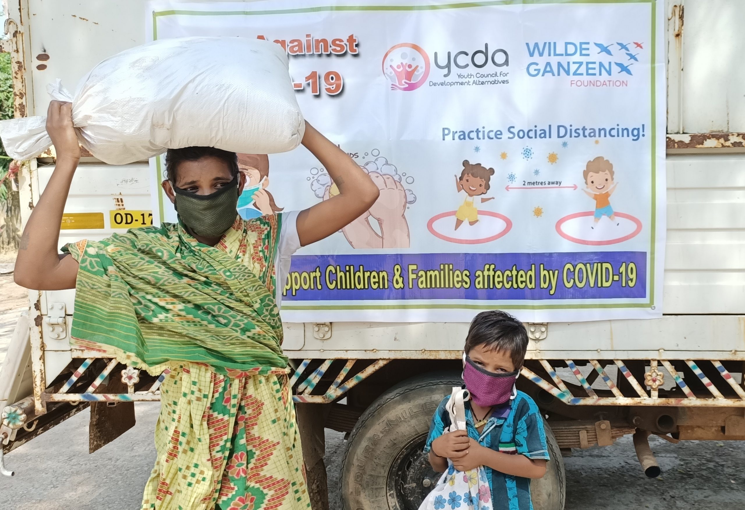 Een vrouw draagt een zak met voedsel op haar hoofd in India