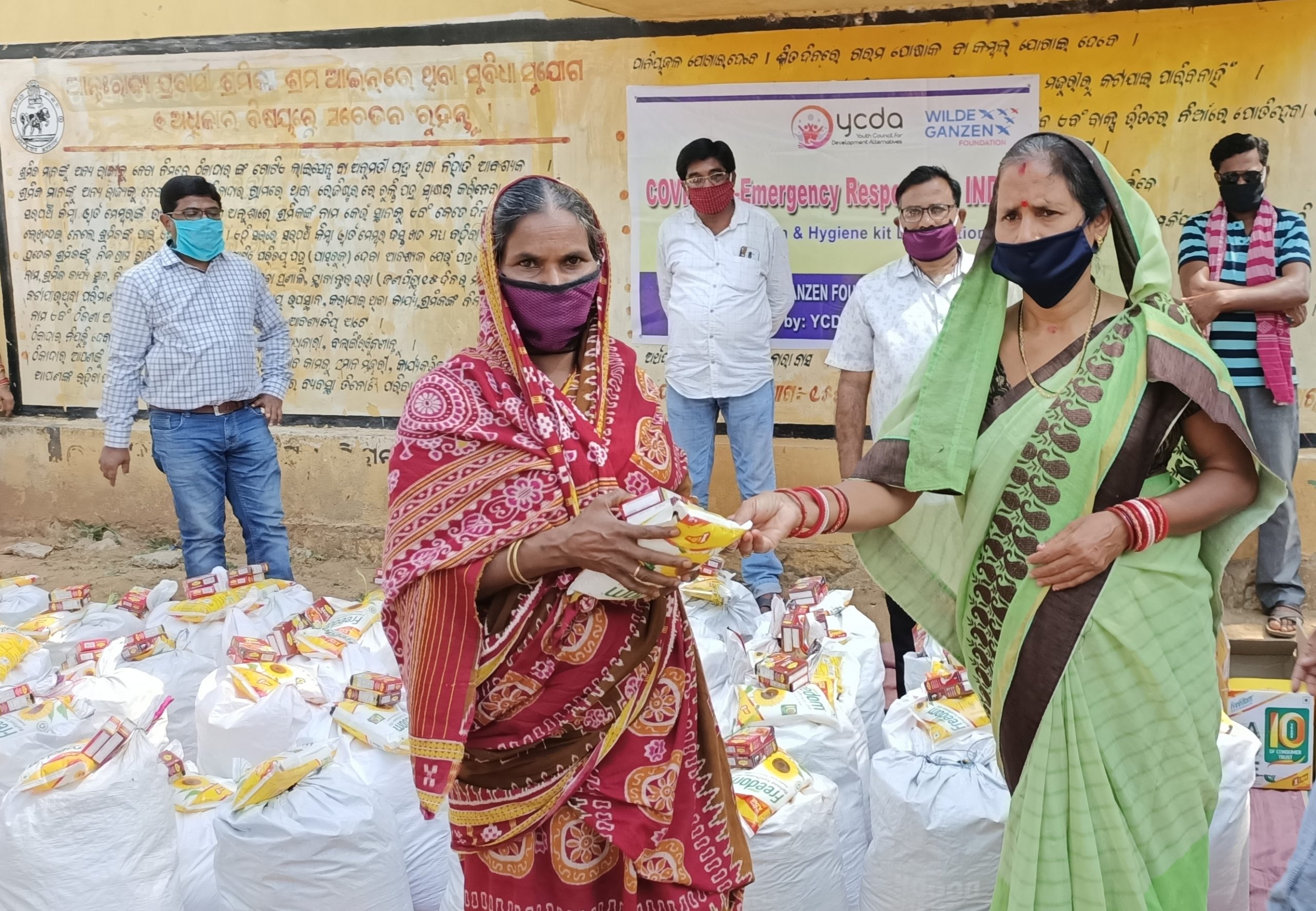Een groep vrouwen bij zakken met voedsel in India